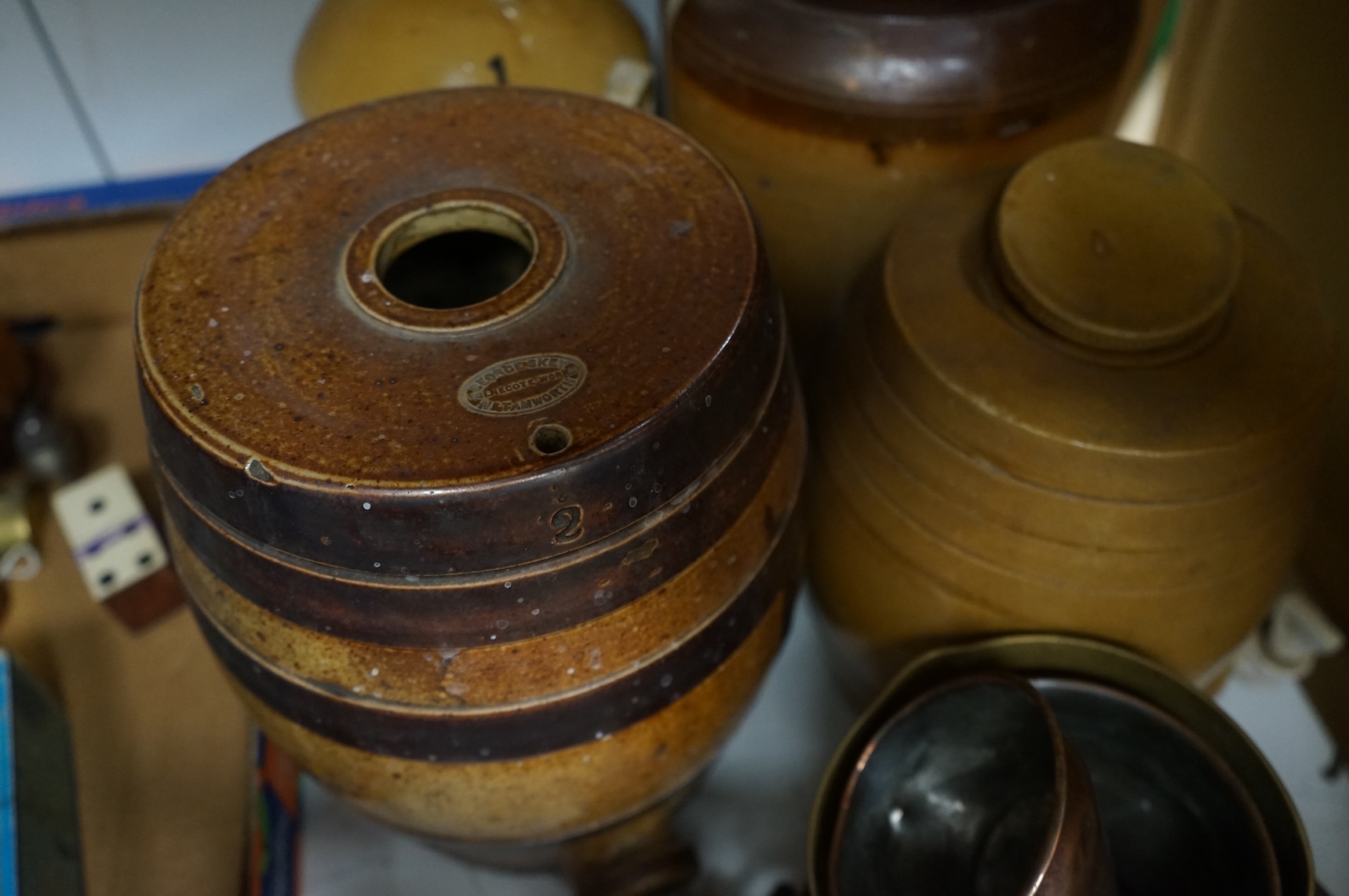 Four Victorian stoneware flagons / jars, five copper/brass saucepans and a funnel, largest 33cm high